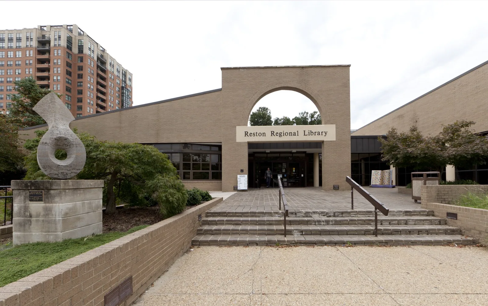 The entrance of the Reston Regional Library, with a sculpture beside the front steps