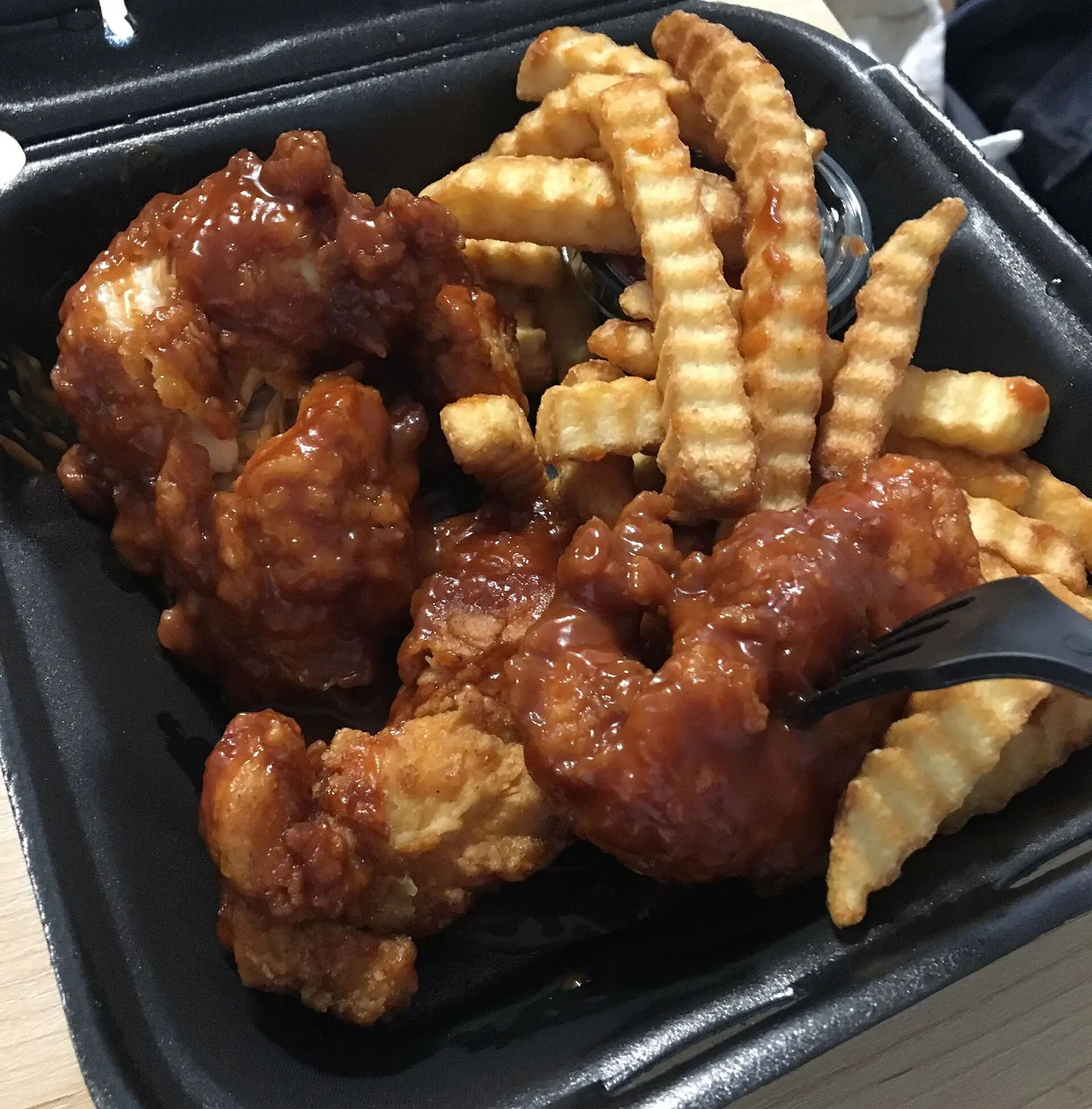 A plate of boneless chicken wings with a side of fries